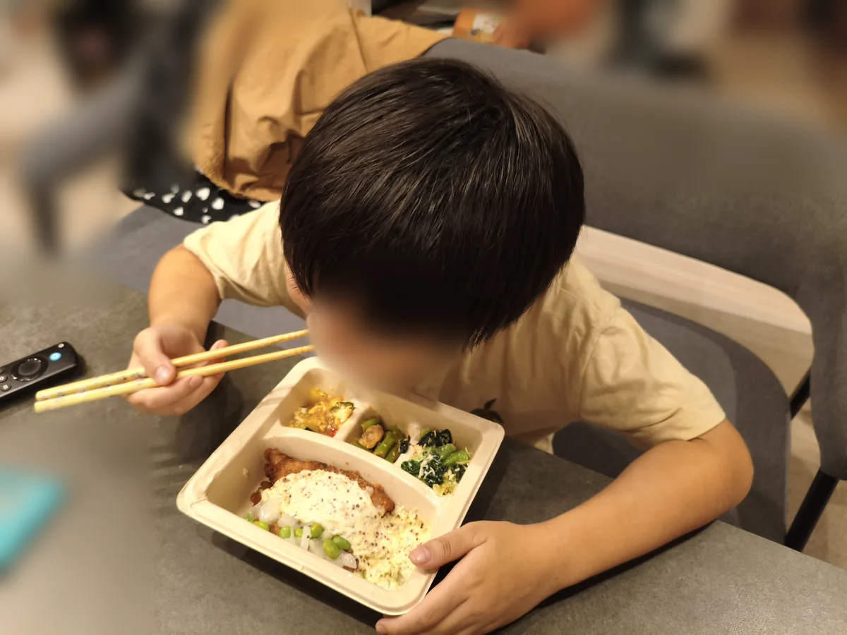 小学生の息子がナッシュのたらフライを食べているところ